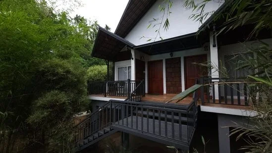 "Twin Bedroom Pillar Cottage at Vintage Garden Resort, showcasing traditional concrete pillars and a serene garden setting, designed for comfort and relaxation."